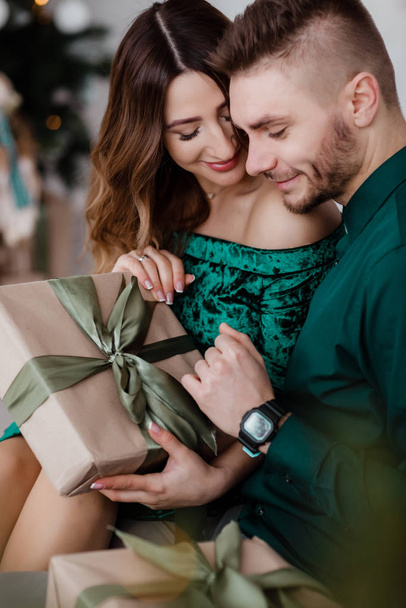 Opening christmas present. Couple in love happy enjoy christmas holiday celebration. Loving couple cuddle smiling while unpacking gift christmas tree background.What a surprise. - 写真・画像