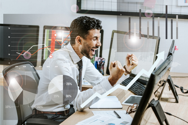 happy bi-racial trader showing yes gesture near charts and graphs - Photo, Image