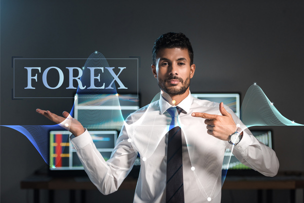 bi-racial trader pointing with finger at forex letters  - Foto, imagen