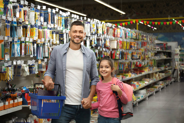 Little girl with father choosing school stationery in supermarket - Zdjęcie, obraz