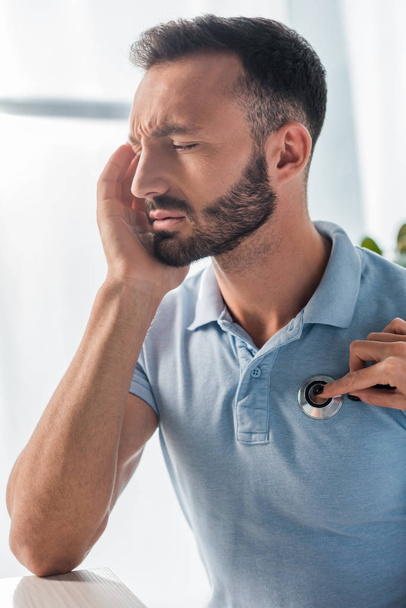 levágott kilátás orvos vizsgálata szakállas férfi fejfájás  - Fotó, kép