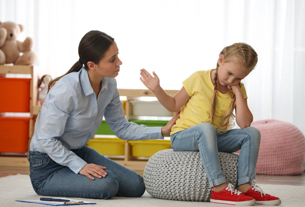 Psicoterapeuta infantil trabajando con una niña en el consultorio
 - Foto, Imagen