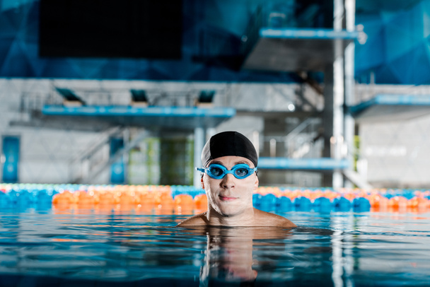 nadador en googles y gorra de natación mirando a la cámara
  - Foto, Imagen
