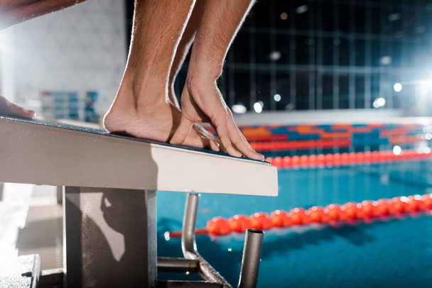 cropped view of athletic sportsman standing on diving block - Foto, imagen