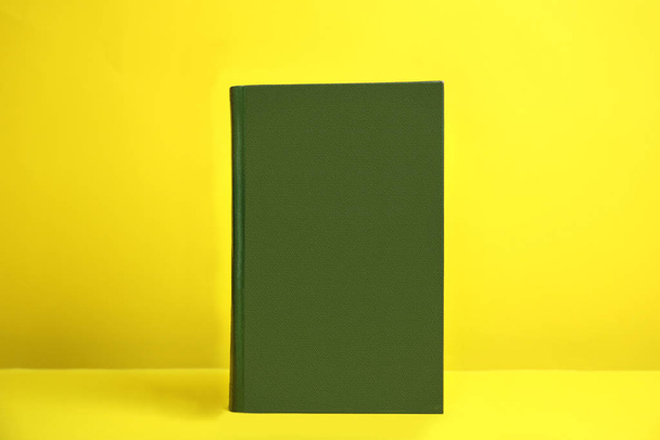 Hardcover book on yellow background. Space for design - Zdjęcie, obraz