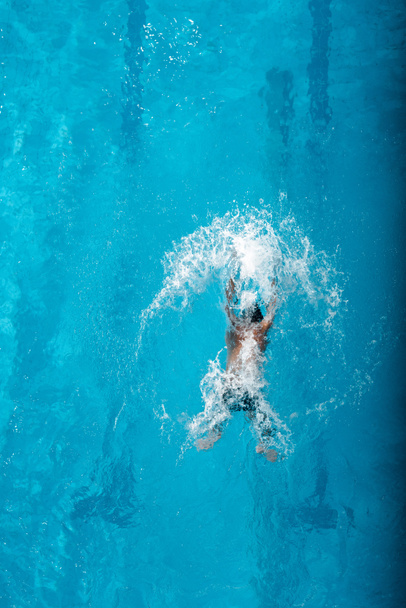 vista superior do mergulho do nadador na água na piscina
  - Foto, Imagem