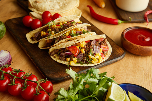 Traditional mexican tacos with vegetables and parsley on wooden table - Foto, imagen