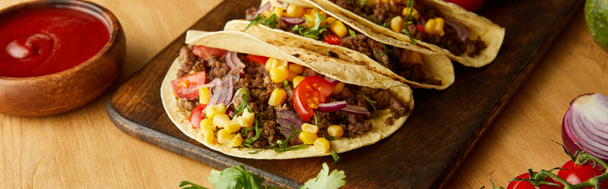 Delicious tacos with ketchup and vegetables on wooden background, panoramic shot - Photo, Image