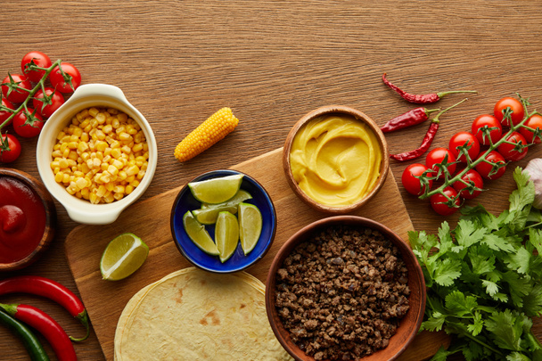 Top view of tortillas with fresh ingredients on wooden background - Φωτογραφία, εικόνα