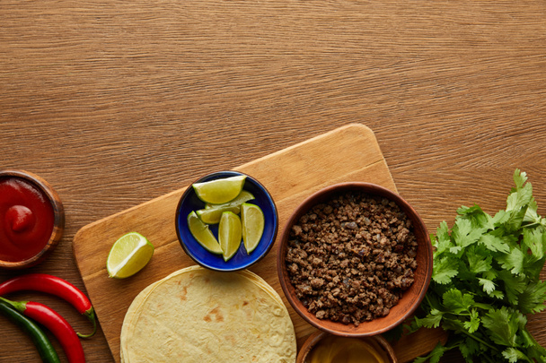 Tahta arkaplanda taco malzemelerinin en üst görünümü - Fotoğraf, Görsel