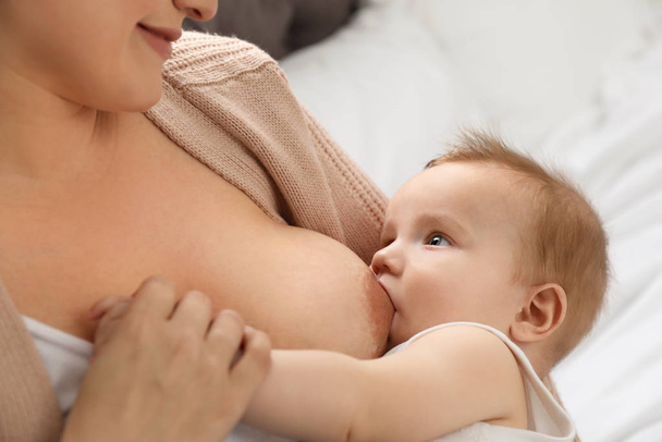 Woman breastfeeding her little baby at home - Foto, afbeelding