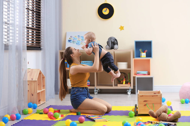 Adolescente niñera jugando con lindo bebé en casa
 - Foto, Imagen
