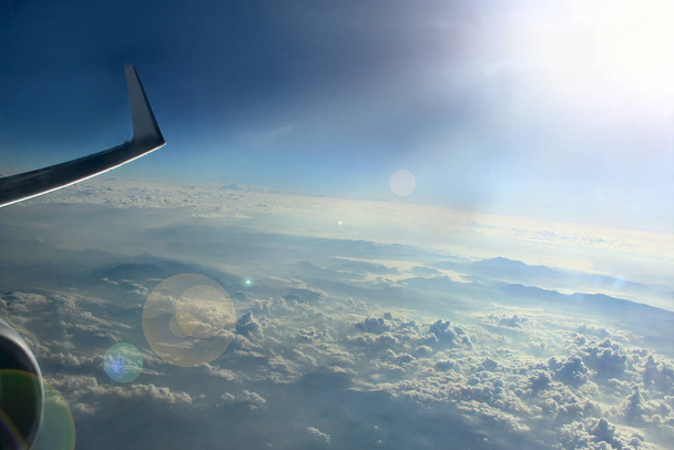 Bulutlar üzerinde sabah güneşinde uçağın penceresinden güzel görünümü - Fotoğraf, Görsel