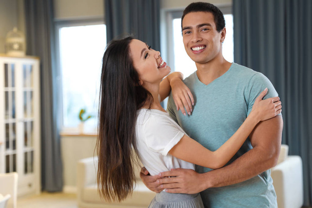 Adorável jovem casal interracial dançando em casa
 - Foto, Imagem