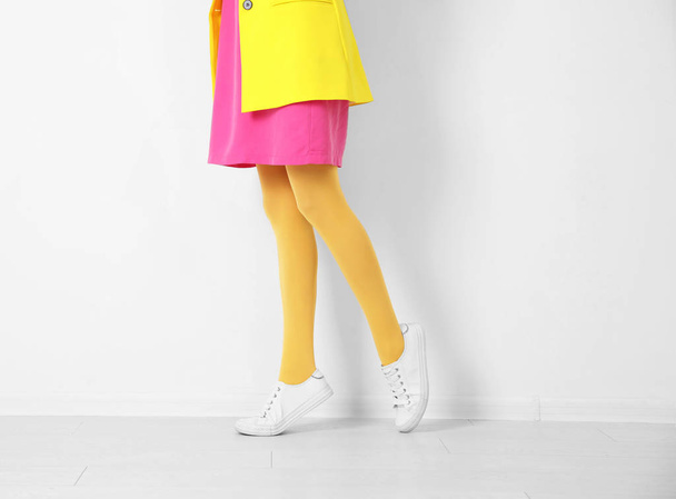 Woman wearing yellow tights near white wall, closeup - Foto, imagen