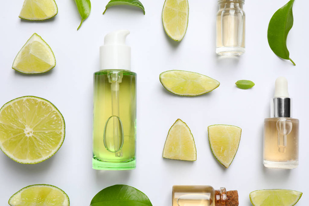 Composition with lime essential oil on white background, top view - Foto, afbeelding