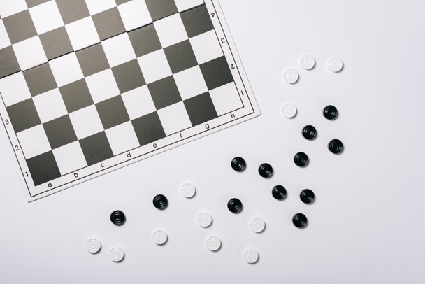 A fehér alapon elszigetelt sakktábla és dámajáték felülnézete - Fotó, kép