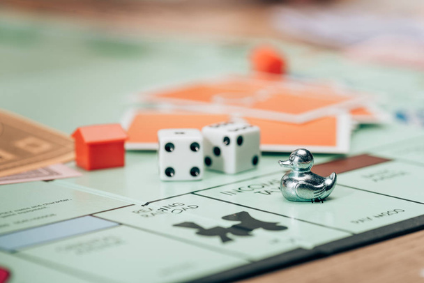 KYIV, UKRAINE - NOVEMBER 15, 2019: Selective focus of monopoly game with figures, cards and dices on table - 写真・画像