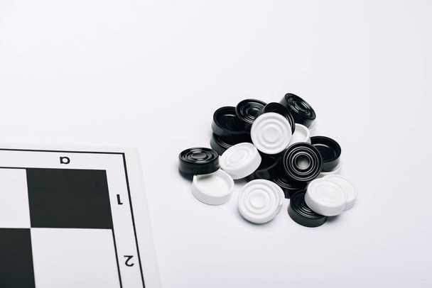 Белые и черные жулики с помощью черной доски изолированы на белых
 - Фото, изображение