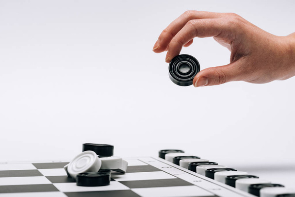 Vágott kilátás nő gazdaság fekete checker sakktáblával elszigetelt fehér - Fotó, kép