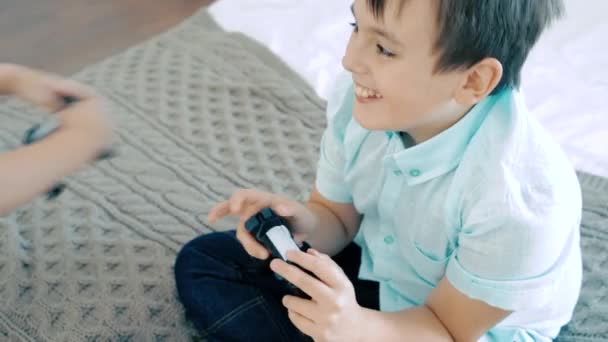 Two friends or brothers smiling and having fun playing a video game with controllers - 映像、動画