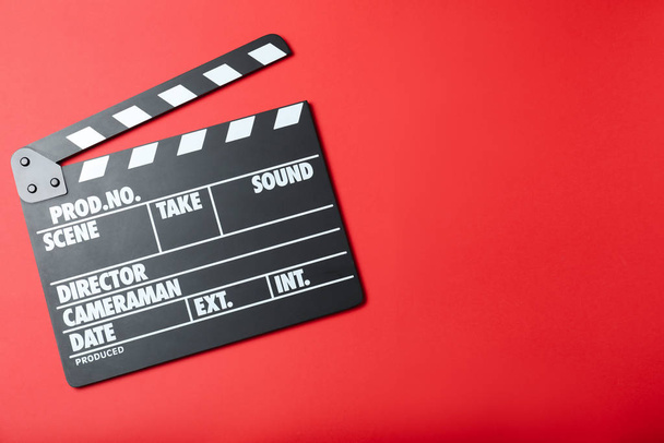 Klapptafel auf rotem Hintergrund, Draufsicht mit Platz für Text. Filmproduktion - Foto, Bild