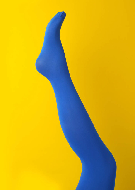 Leg mannequin in blue tights on yellow background - Zdjęcie, obraz