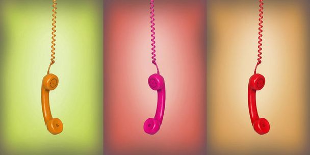 Yellow, pink and red vintage phones hanging of a cable - Фото, зображення