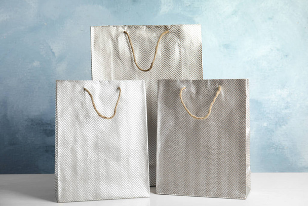 Silver shopping paper bags on white table - Foto, imagen