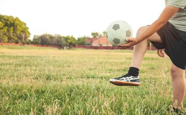 Kaukasische jongen met een voetbal op een voetbalveld. - Foto, afbeelding