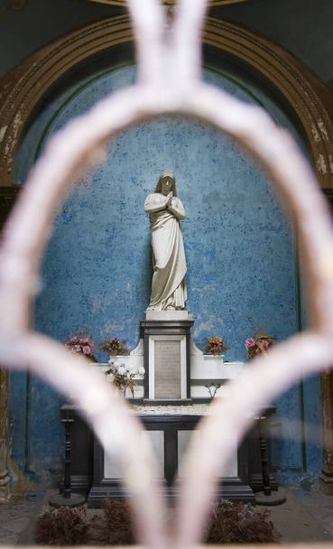 Estátua de uma virgem orante em uma capela em um cemitério
 - Foto, Imagem