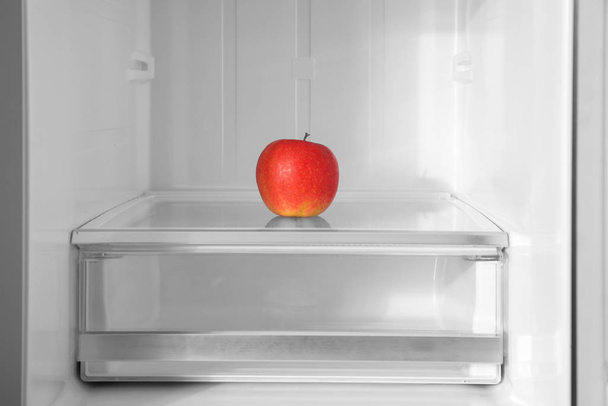 Red apple on shelf inside modern refrigerator - Fotografie, Obrázek