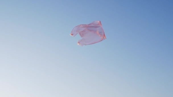 een plastic zak vliegt in de wind tegen de achtergrond van de stad - Video