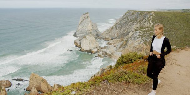 Young woman enjoys the view over the ocean at Cabo da Roca in Portugal - travel photography - Foto, immagini