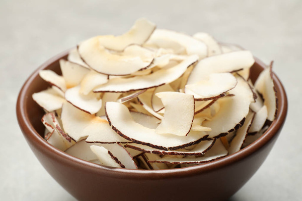 Tasty coconut chips in ceramic bowl, closeup - Foto, imagen