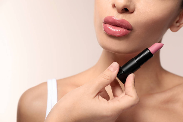 Woman with pink lipstick on light background, closeup - Фото, зображення