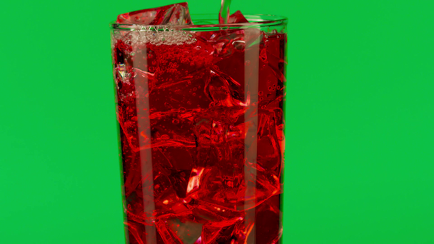 Kaatamalla punaista juomaa lasiin jääkuutioilla vihreää taustaa vasten, lähikuva hidastettuna punaisella
 - Materiaali, video