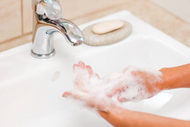 Concepto de higiene. Lavarse las manos con jabón debajo del grifo con w
 - Foto, imagen