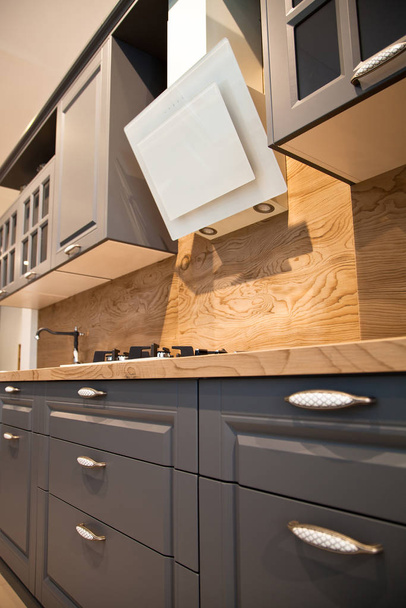 Interior of luxurious wooden modern kitchen grey cabinets - Fotografie, Obrázek