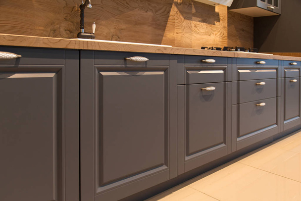 Interior of luxurious wooden modern kitchen grey cabinets - Φωτογραφία, εικόνα