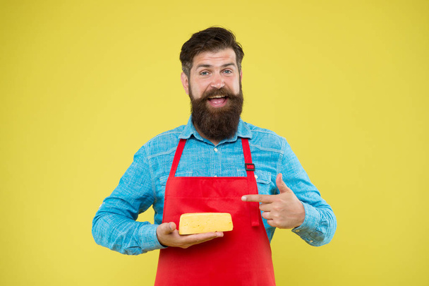 reasonable price and good quality. cheesemaking techniques. cheese maker. hipster with beard in chef apron. Dairy food shop. Online shopping. Gourmet product. happy bearded man hold cheese - Foto, afbeelding