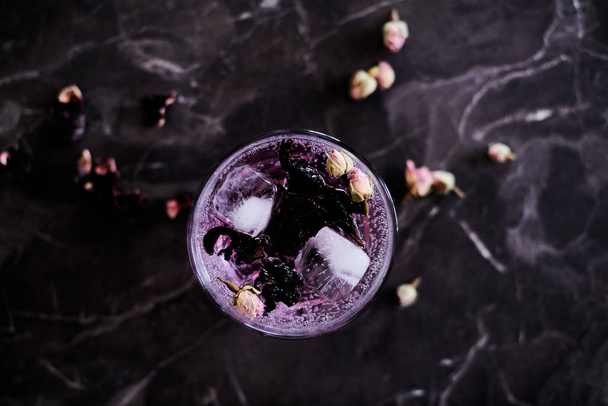 Pink Gin and Tonic cocktail with Hibiscus and Dried Rose Buds - Foto, Imagen