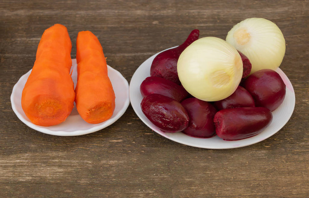 Червоний буряк, морква відварюють і цибулю в процесі приготування. приготування салату. Концепція охорони здоров'я овочів
 - Фото, зображення