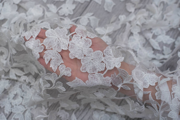 pérolas de costura de mão pérolas para o tecido de seda de renda branca, fazendo um vestido de noiva, decorando com bordado
 - Foto, Imagem