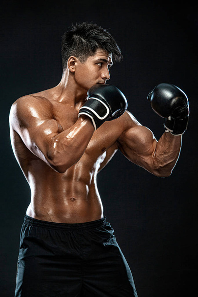 Fitness and boxing concept. Boxer, man fighting or posing in gloves on black background. Individual sports recreation. - Foto, imagen