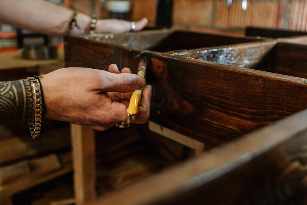 Le mani di un falegname che spazzola un mobile di legno a workshop artigianale
 - Foto, immagini