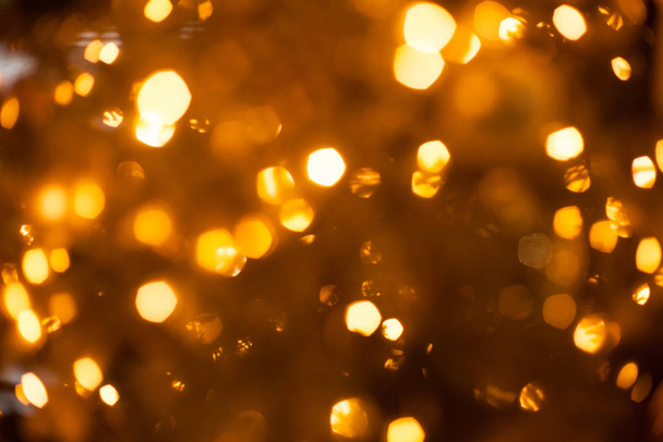 Christmas blurred golden lights out of focus on the tree, festive christmas background - Фото, зображення