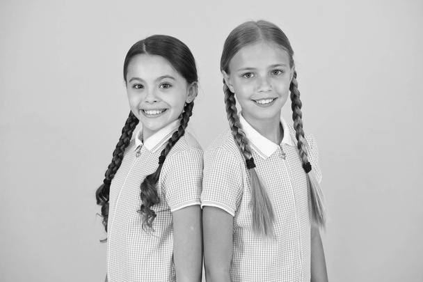 old school fashion. back to school. happy beauty with pigtails. happy childhood. brunette and blond hair. sisterhood concept. best friends. vintage style. small girls in retro uniform. at hairdresser - Φωτογραφία, εικόνα