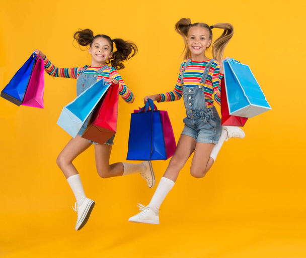 small kids with heavy shopping bags. big sale of presents. happy shopaholic children. little girls care packages. free jump. Summer shopping. Buyer consumer concept. Holiday purchase saving - Foto, Imagen