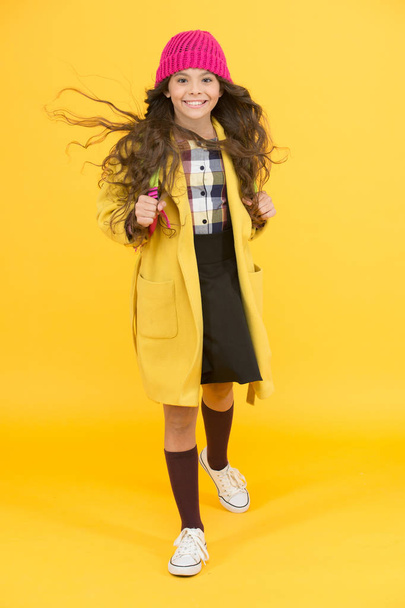 happy pupil kid yellow wall. back to school. desire for study. smiling child craving for education. retro and modern school. small girl enjoy autumn. stylish schoolgirl go forward. go to school - Photo, image